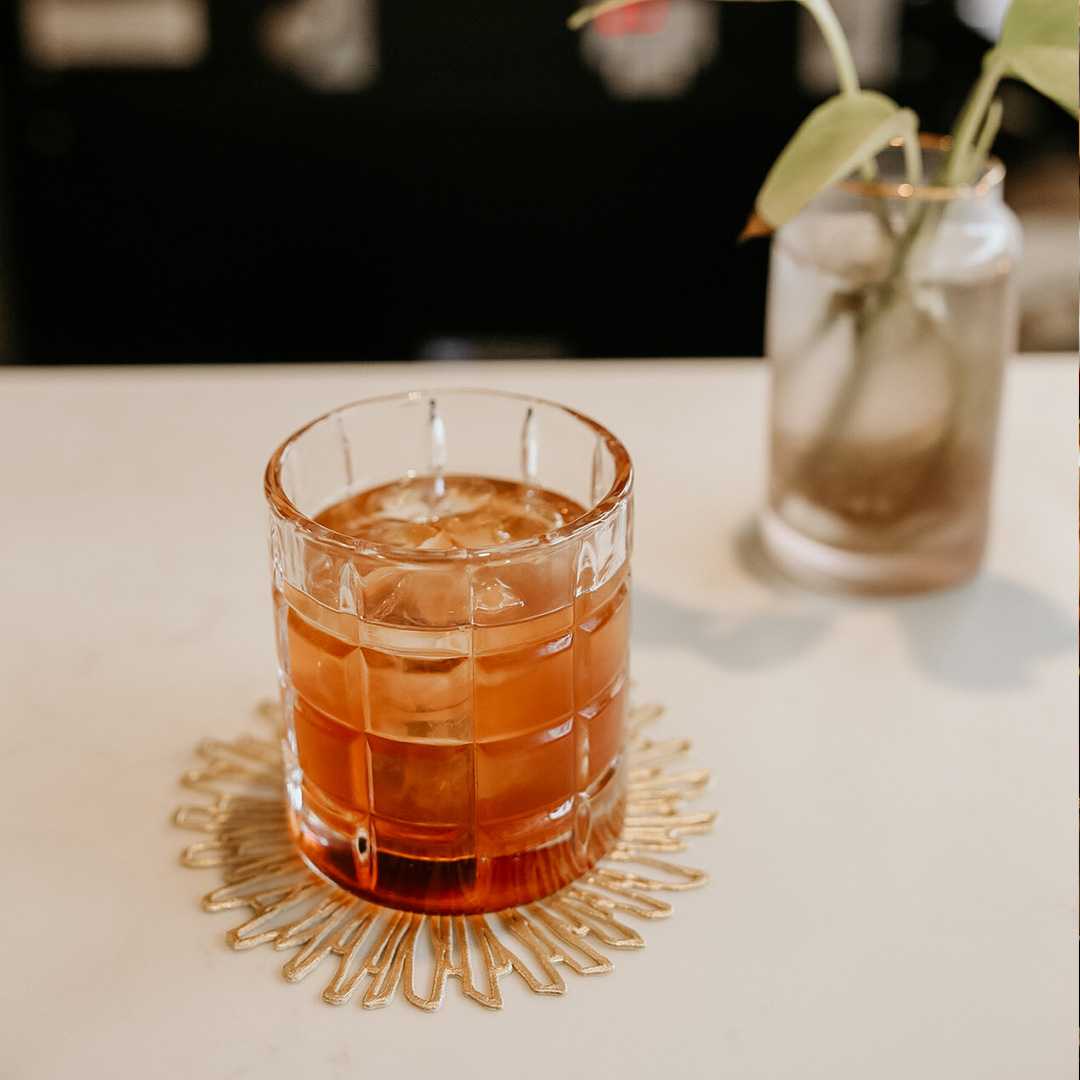 A photo of a pink cocktail in a clear glass on a white table. Photo is from our chattanooga photography marketing package.